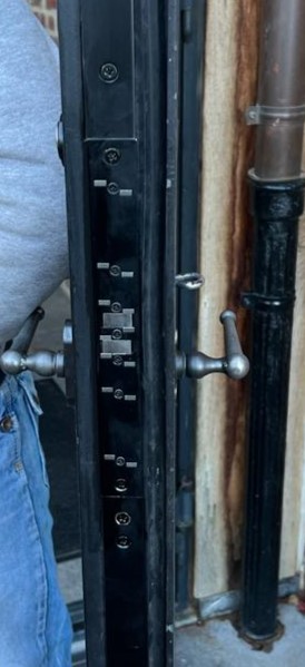 Black lock fitting into a pedestrian door