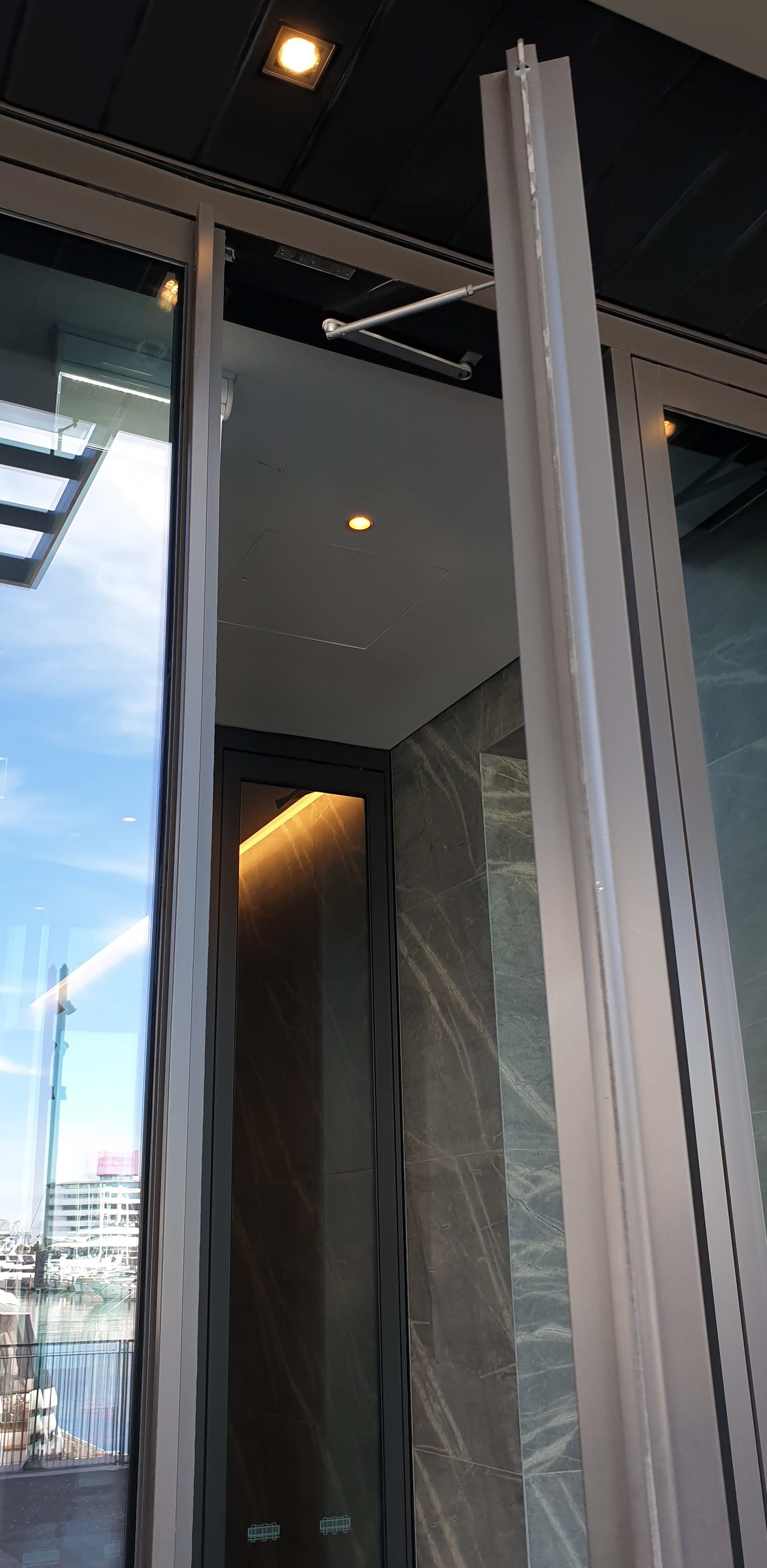 A lock morticed into the header of a hotel entrance door with that needed help aligning when closing