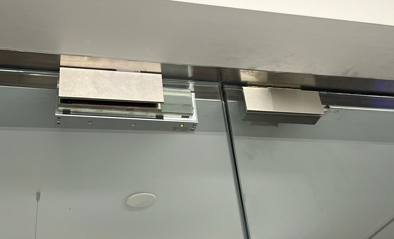 A replacement maglock installed on the right-hand door, with the existing maglock on the left-hand door retained for comparison